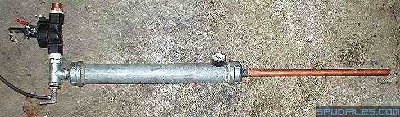 This is the first design that actually worked. It has a male adapter JB Welded into the end cap with a tee on that. The tee leads out on one side to a sprinkler valve and on the other side to a Schrader valve. This design worked but still constricted the airflow a little. Below is a close-up of the rear of the gun.